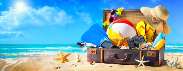 Beach accessories in suitcase on sand. Family holidays concept Preparation for summer vacation. Beach accessories in suitcase on sand. Family holidays concept scuba diving family stock pictures, royalty-free photos & images