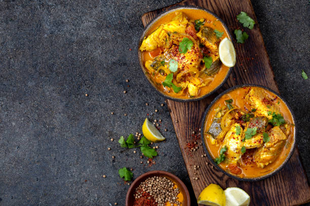 comida india. curry de pescado tradicional de kerala con pan naan, placa gris, fondo negro - bengala del oeste fotografías e imágenes de stock