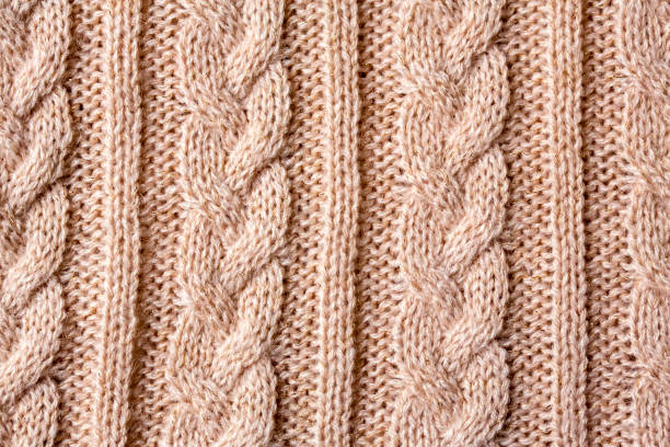 istock pink beige cable stitch knitted woolen background 1147077335