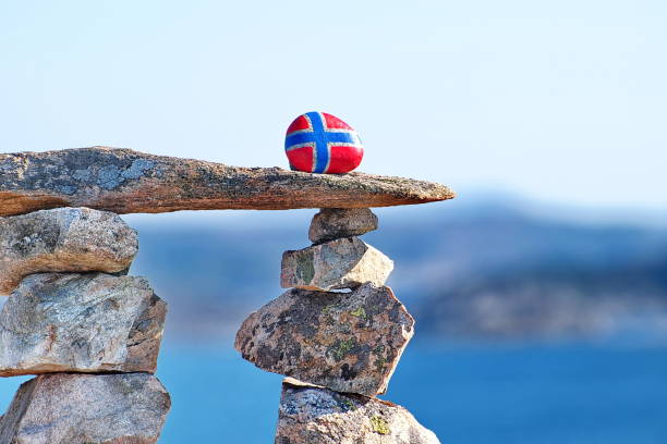 Stone balancing pyramid with the image of the Norwegian flag on the top stone. Concept of Norwegian Constitution Day.  Celebrated on May 17.