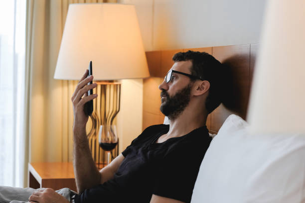 istock Relaxed man reading an ebook or tablet laying on a comfortable bed 1147079597
