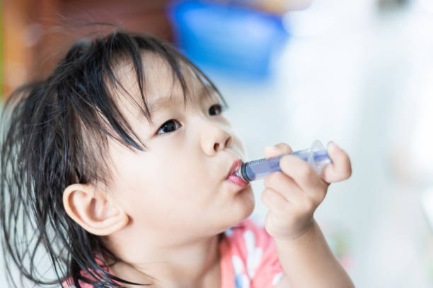 istock Little baby child feeding herself with water in syringe 1147081002