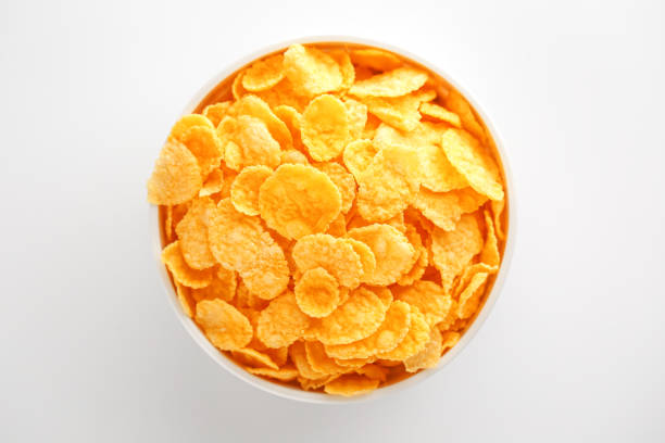 istock White cup with golden corn flakes isolated on white background. View from above. Delicious and healthy breakfast 1147083152