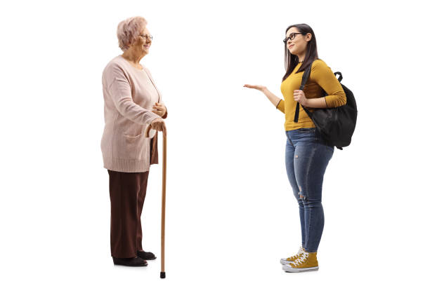 mujer mayor con un bastón y una estudiante femenina que gesticulan con la mano - grandmother standing senior women senior adult fotografías e imágenes de stock