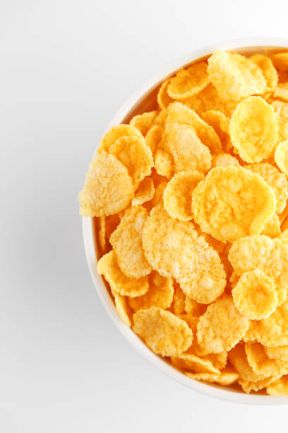 istock White cup with golden corn flakes isolated on white background. View from above. Delicious and healthy breakfast 1147083382