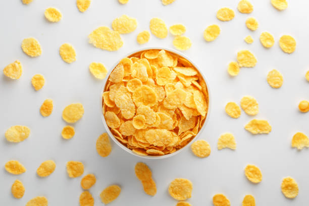istock White cup with golden corn flakes, isolated on white background. Hopya crumbled around the cup. View from above 1147083542