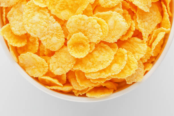 istock White cup with golden corn flakes isolated on white background. View from above. Delicious and healthy breakfast 1147083762