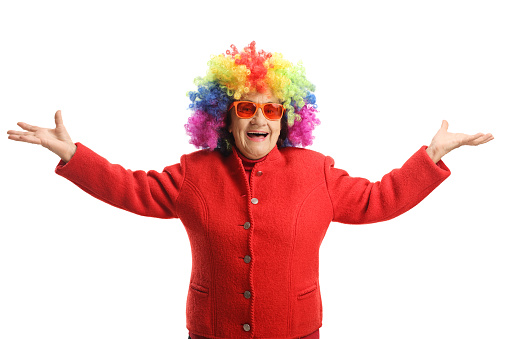 Happy elderly lady with a red coat and a colorful wig isolated on white background