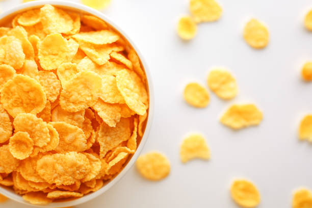 istock White cup with golden corn flakes, isolated on white background. Hopya crumbled around the cup. View from above 1147086985