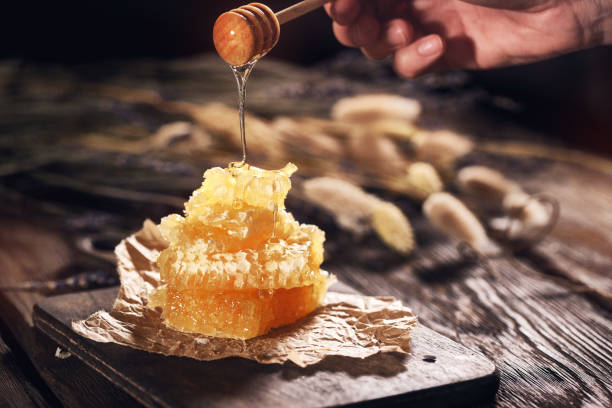 istock Honeycomb and bamboo dipper on wooden table 1147088138