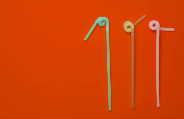 istock Colored cocktail tubes on orange pastel background. Top view. Copy space. Minimalist trend. 1147090034