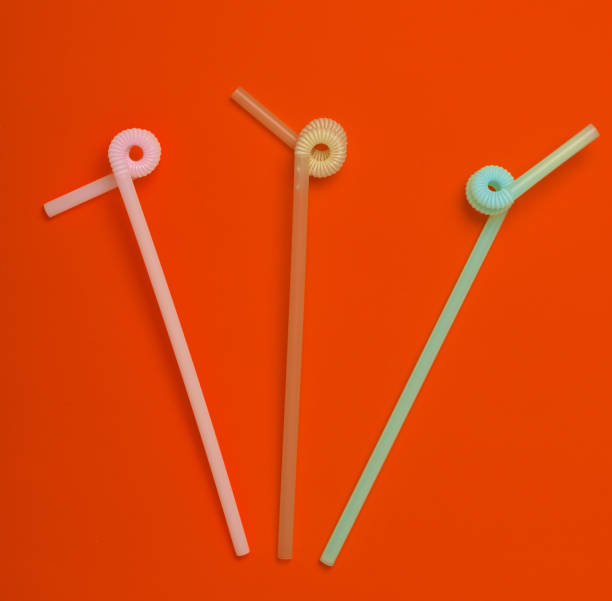istock Colored cocktail tubes on orange background. Top view. Copy space. Minimalist trend. 1147090048