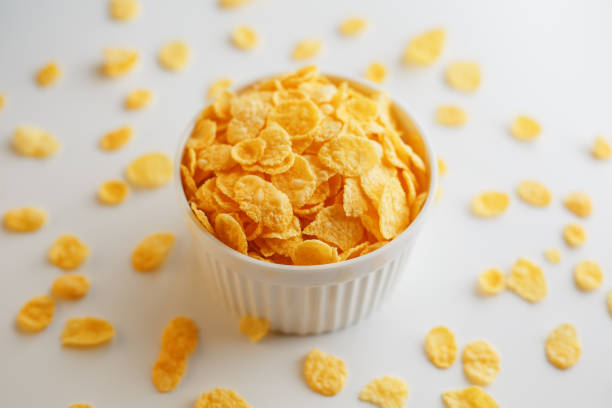 istock White cup with golden corn flakes, isolated on white background. Hopya crumbled around the cup. View from above 1147091423