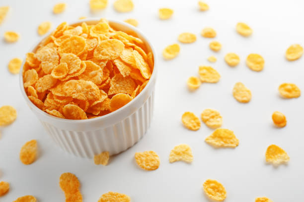 istock White cup with golden corn flakes, isolated on white background. Hopya crumbled around the cup. View from above 1147091828