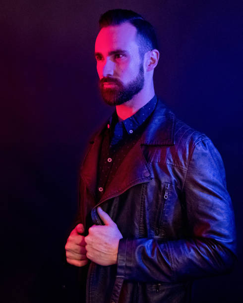 istock Handsome man wearing a leather jacket with blue and red gel lighting 1147092557