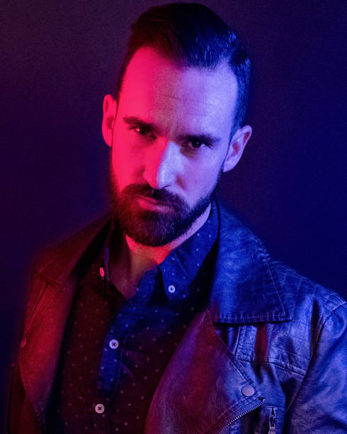 istock Handsome man wearing a leather jacket with blue and red gel lighting 1147092658