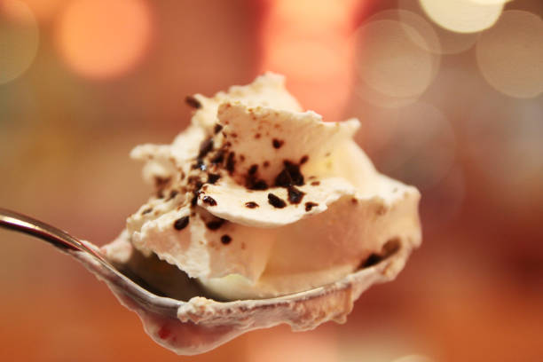 Cold coffee drink frappe with whipped cream on spoon and beautiful bokeh light