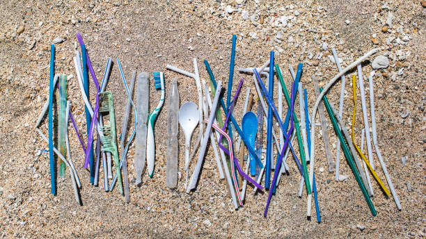 istock Heap of different plastic waste: straws and single-use spoons, toothbrush and comb collected on the beach on sand background 1147098196