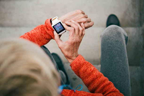 Active senior woman checks her heart rate on smart watch