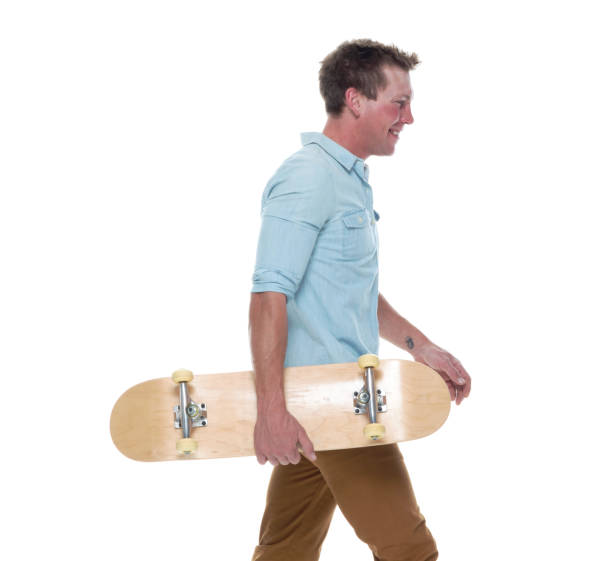 istock Casual well dressed man walking with a skateboard 1147099061