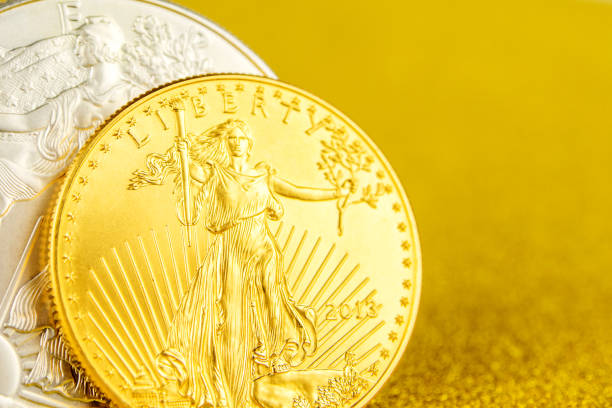 istock silver eagle and golden american eagle one ounce coins on golden background 1147102404