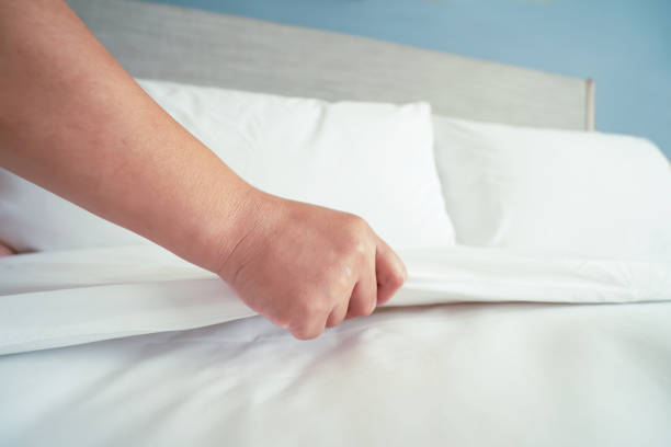 istock Female Hand set up white bed sheet in room hotel 1147103661