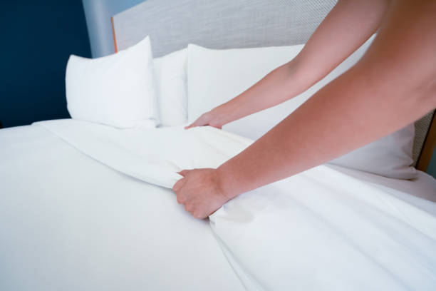 istock Female Hand set up white bed sheet in room hotel 1147103674