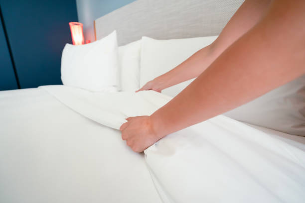 istock Female Hand set up white bed sheet in room hotel 1147103682