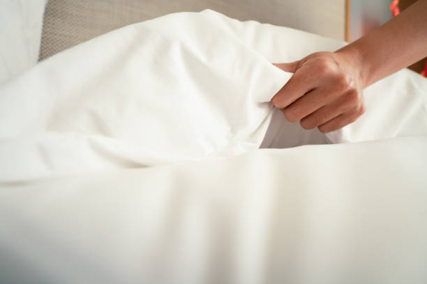 istock Female Hand set up white bed sheet in room hotel 1147103686