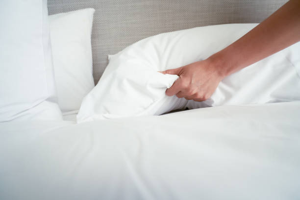 istock Female Hand set up white bed sheet in room hotel 1147103705