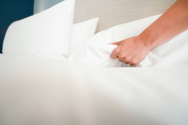 istock Female Hand set up white bed sheet in room hotel 1147103714