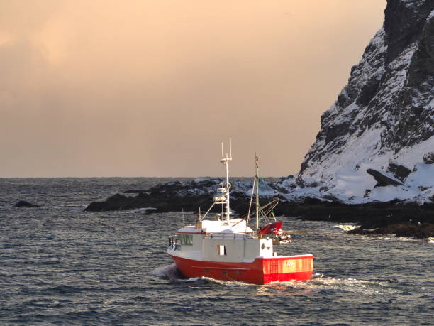 Kamoyvaer, Mageroya island, Finnmark county, Norway, 10 march 2019 : red boat from the village of Kamoyvaer, one of the northest fishing village of the world (71.05°N)
