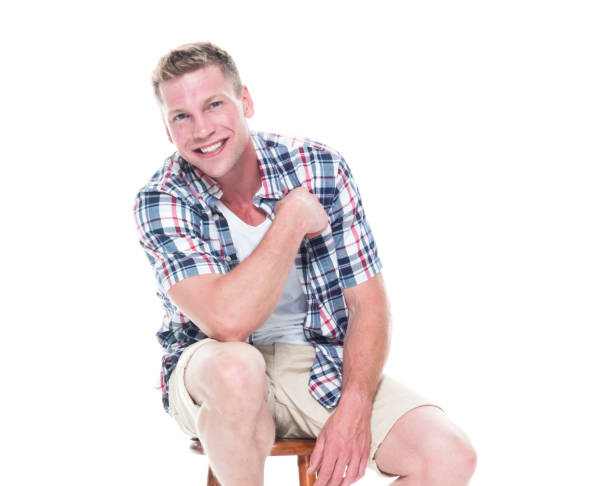 istock Handsome man in shirt and shorts is sitting on stool 1147104953