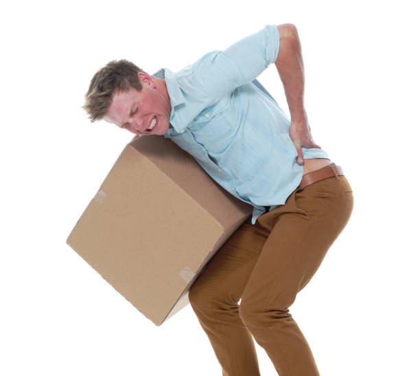 istock Good looking man holding a brown box and has back pain 1147105961