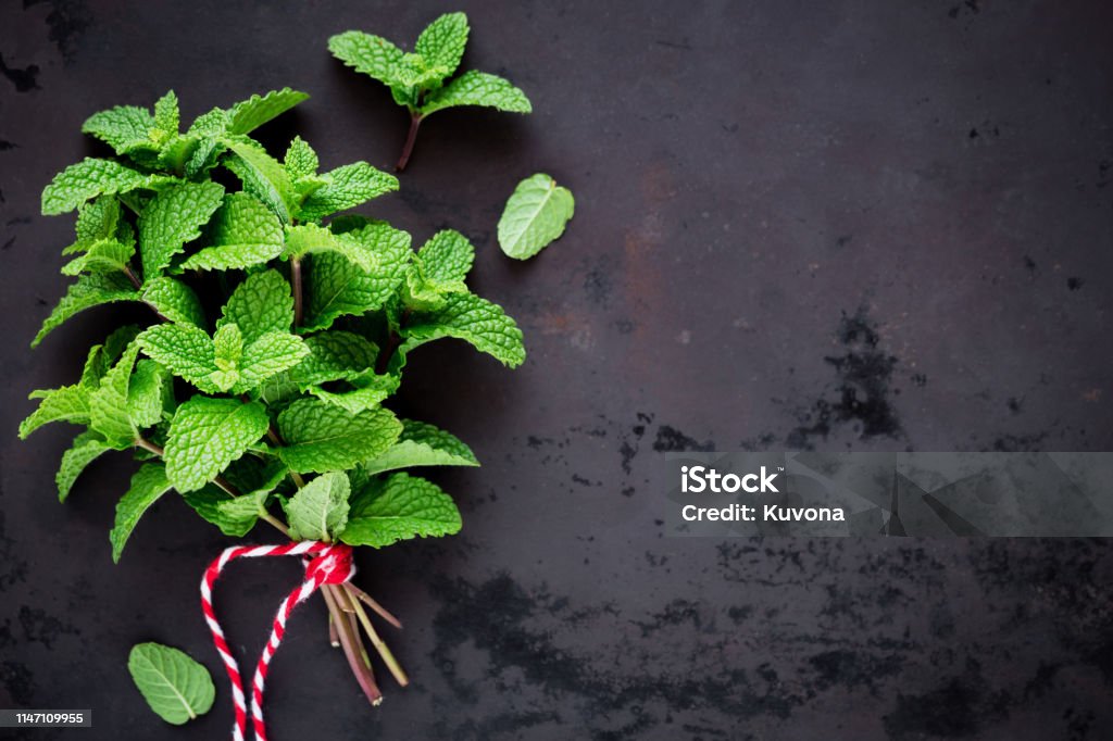 Fresh mint in a bunch A bunch of fresh mint against dark rustic background. Overhead view Peppermint Stock Photo
