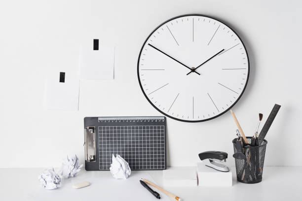 istock Office supplies and wall clock on white 1147114115