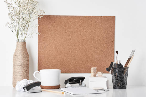 Cork board with office supplies on white background