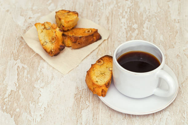 włoskie suche herbatniki biscotti z filiżanką kawy lub czarną herbatą na drewnianym stole. proste jedzenie, rustykalny styl. selektywne skupienie. - biscotti cookie coffee tea zdjęcia i obrazy z banku zdjęć