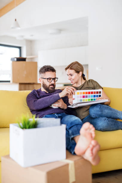 istock A young couple with color samples sitting on sofa, moving in new home. 1147126718