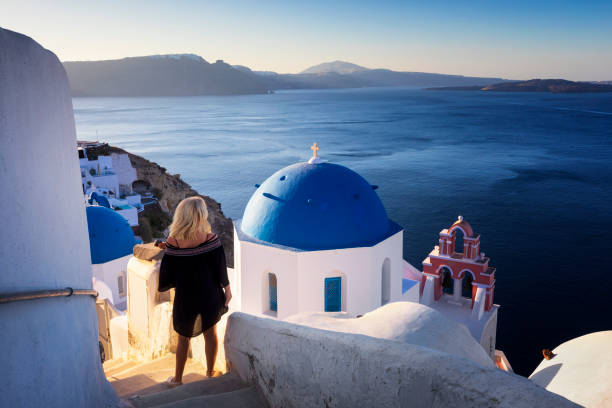 la mujer joven mira el paisaje marino, santorini, oia, grecia - santorini greece church travel fotografías e imágenes de stock