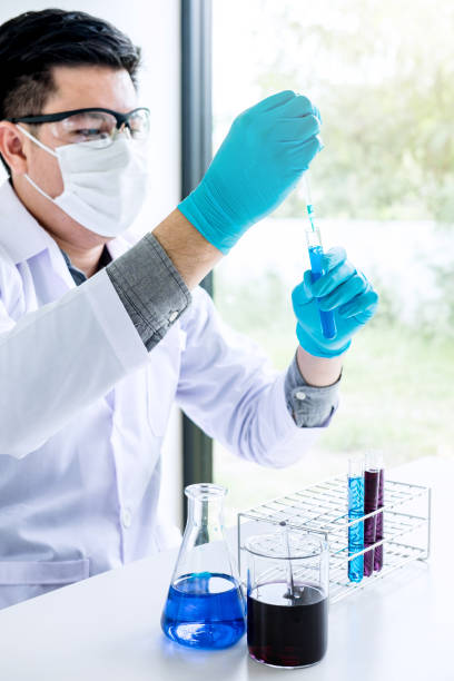istock Biochemistry laboratory research, Chemist is analyzing sample in laboratory with equipment and science experiments glassware containing chemical liquid 1147128299