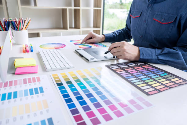 istock Image of male creative graphic designer working on color selection and drawing on graphics tablet at workplace with work tools and accessories 1147128302