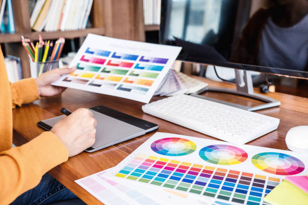 istock Image of female creative graphic designer working on color selection and drawing on graphics tablet at workplace with work tools and accessories 1147128321