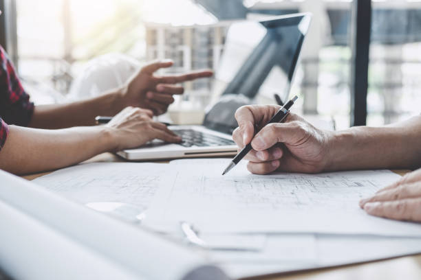 istock Hands of architect or engineer working on blueprint meeting for project working with partner on model building and engineering tools in working site, Construction and structure concept 1147128350