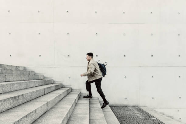 istock Young man running up steps in urban setting 1147129765
