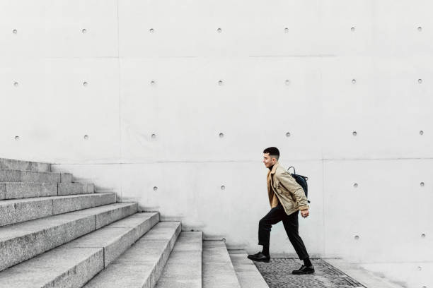 istock Young man running up steps in urban setting 1147129824