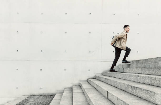 istock Young man running up steps in urban setting 1147129883