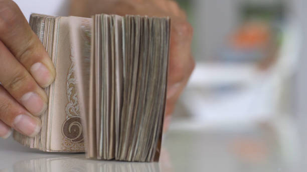 Close up hands counting of thousansds Thai baht money.Close up Human counting Thai banknote, richman count and holding hundred. Baht bills on table Close up hands counting of thousansds Thai baht money.Close up Human counting Thai banknote, richman count and holding hundred. Baht bills on table thailand king stock pictures, royalty-free photos & images