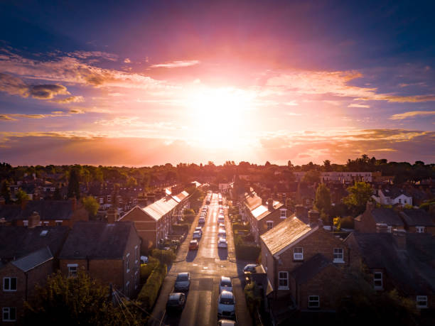 Sun rising above a traditional British housing estate with countryside in the background. stock photo