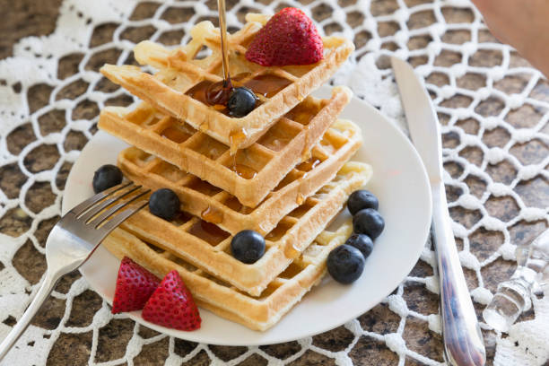 istock stack of golden brown waffles topped with fruit and syrup 1147132153